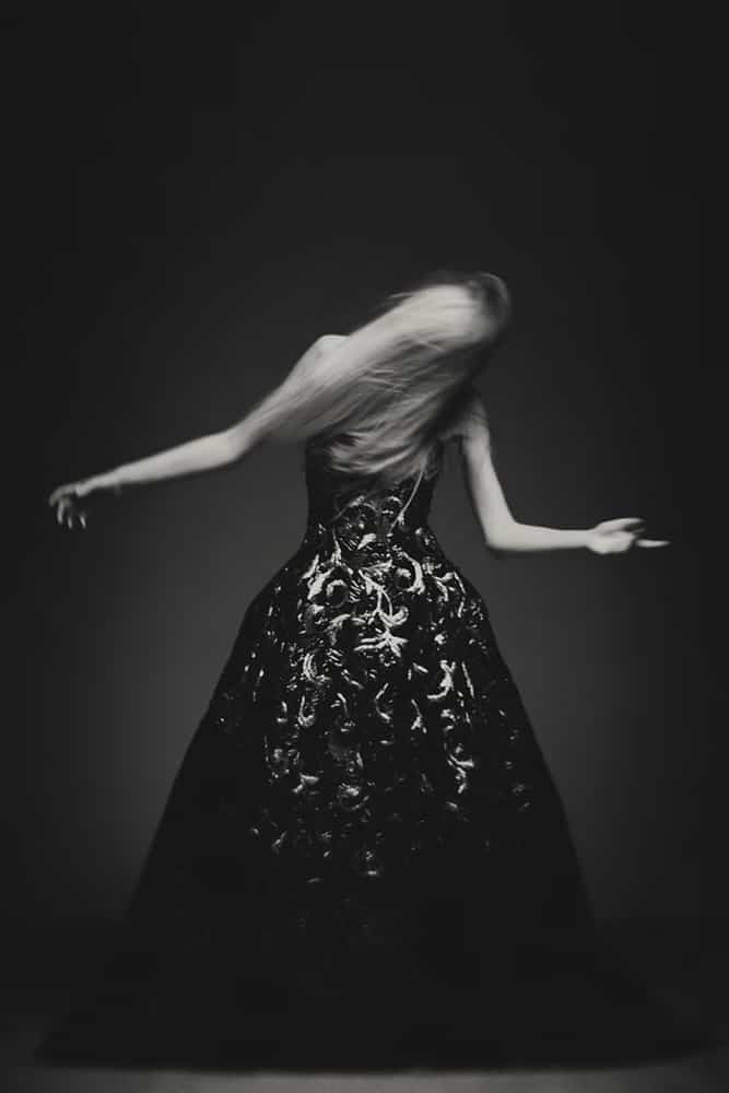 A couture gown blurred in motion in a fashion study.