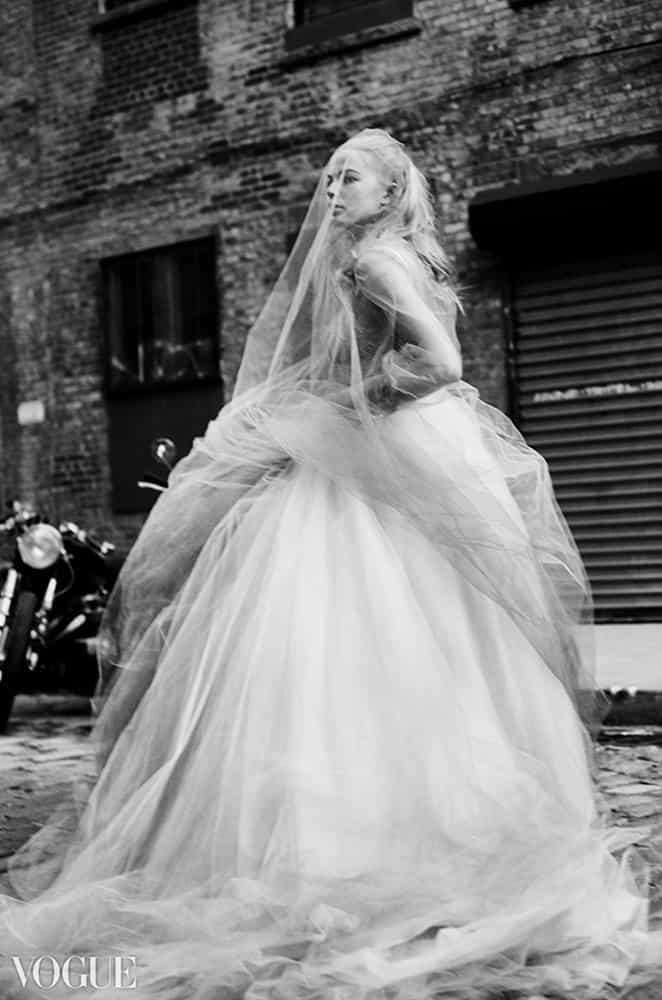 A fashion figure in a gown photographed in a street setting.