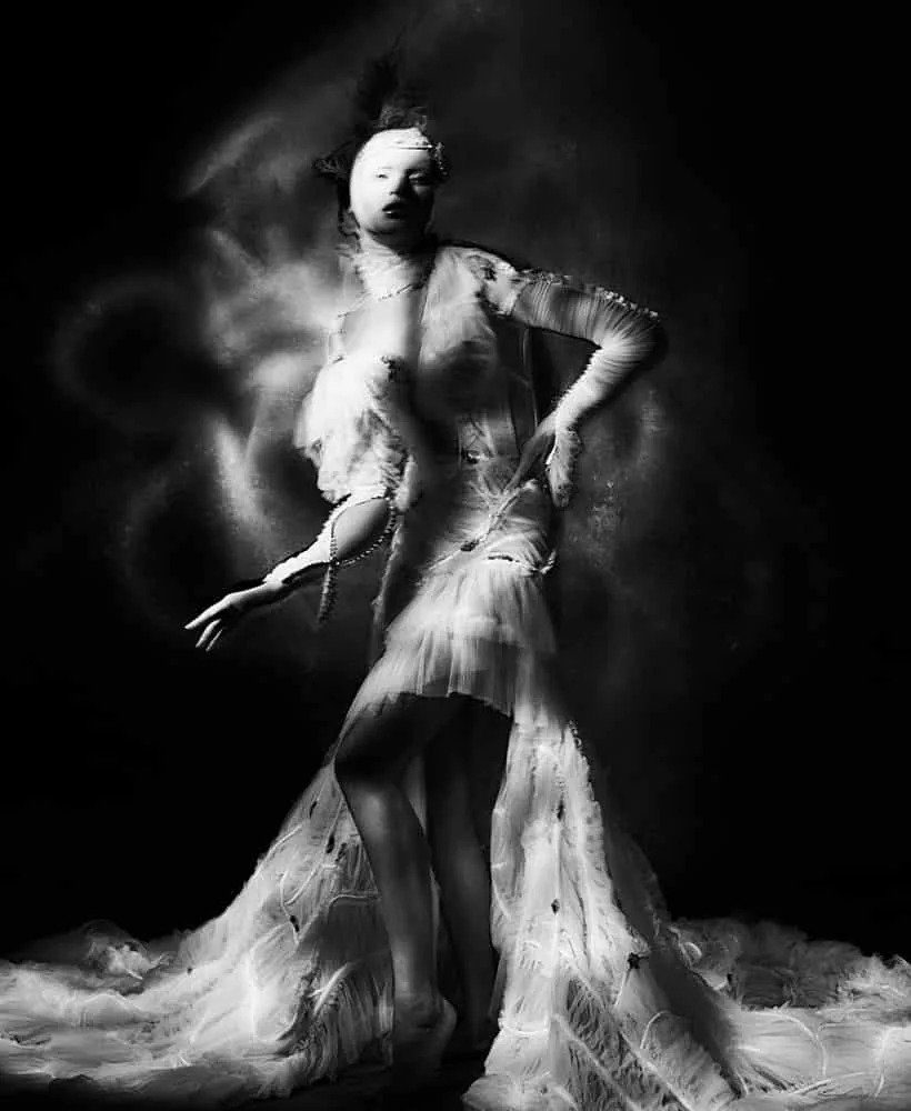 A portrait emerging from black through a narrow field of painted light.
