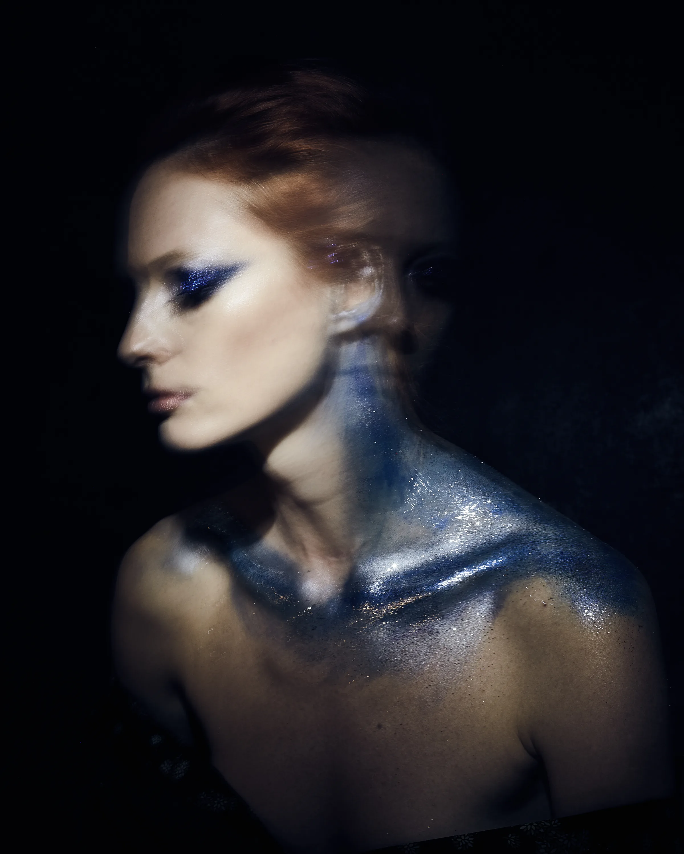 A portrait emerging from darkness through painterly light.