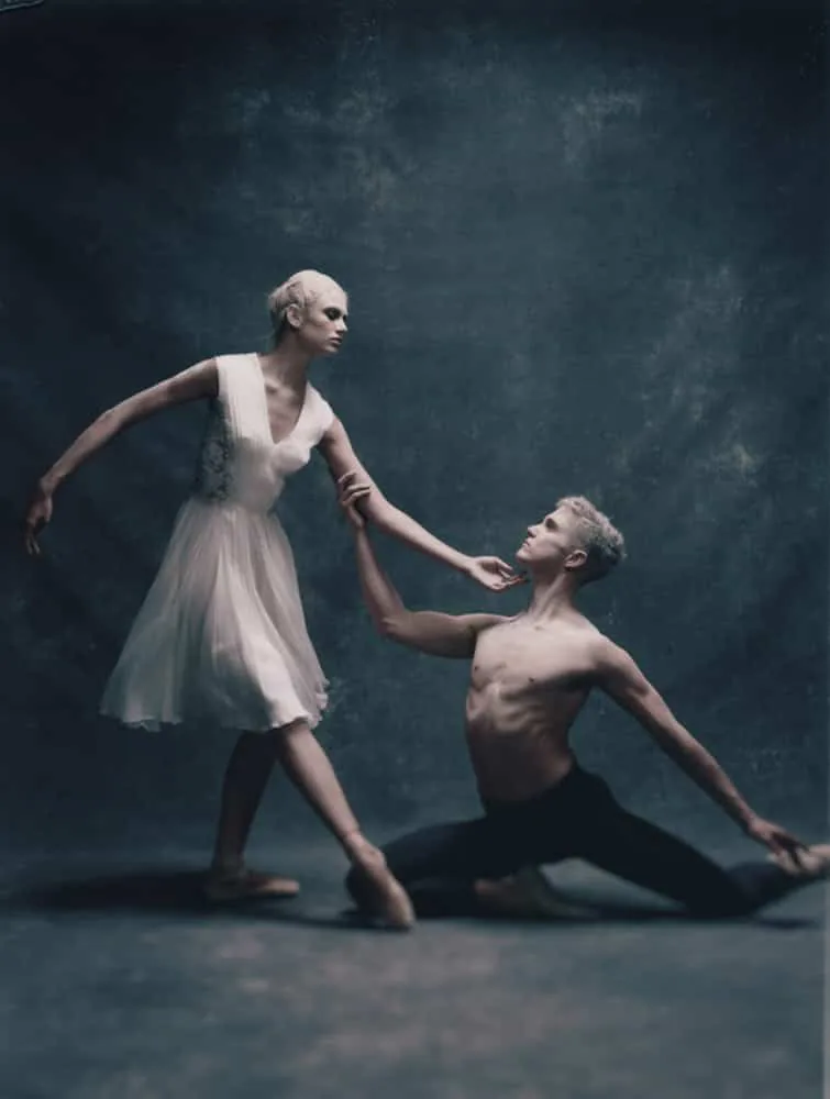 Two figures meet in a staged movement study.