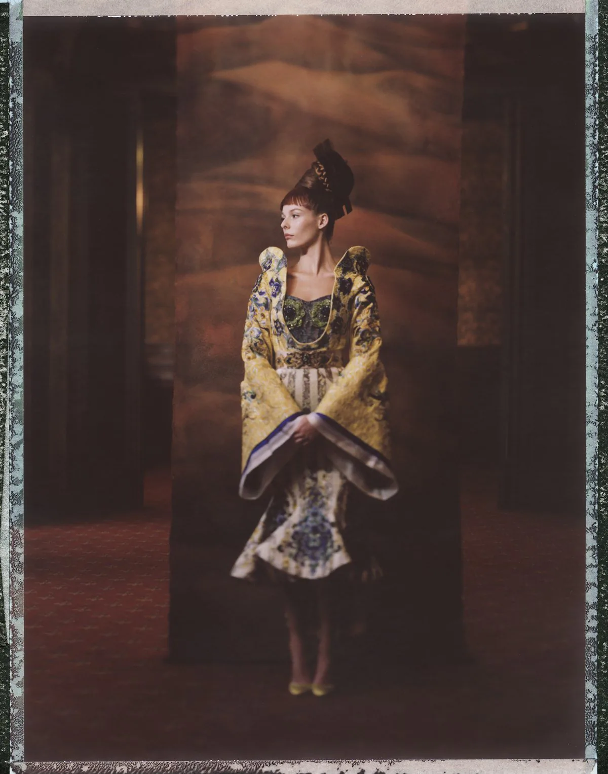 A couture figure photographed on large-format instant film.